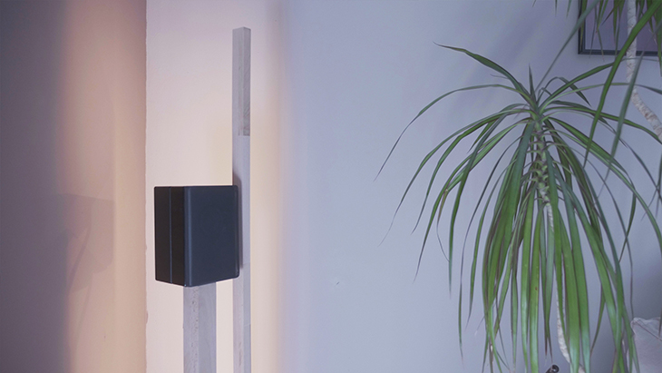 Une lampe led RVB et un pied d'enceinte sobre en bois